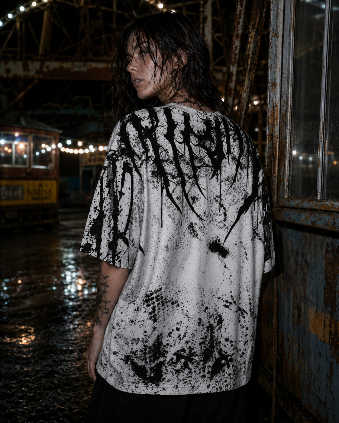 Model Ava wearing the black blood Shirt by Frostbite Apparel from the back, showing the aggressive dripping black graphic.